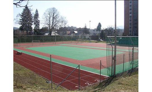 Sportovní hala v centru dění s tenisovým kurtem a hřištěm.